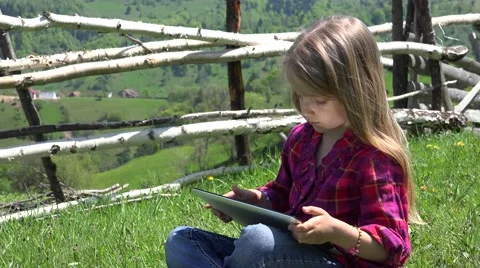 4K Child Playing Tablet on Meadow, Little Girl Kid Using Typing Ipad PC Computer Stock Footage 42230416