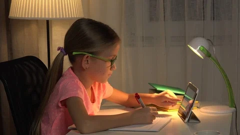 4K Child Uses Tablet For Studying, Girl Writing Homework in Night Internet Usage Stock Footage