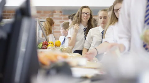4K Children in school cafeteria queuing up at electronic till to scan food items Stock Footage 67851979