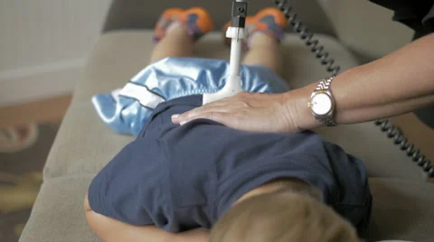 4k Chiropractor adjusts young boy Stock Footage 40296467