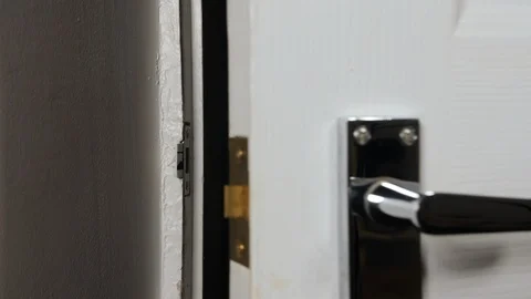 4K chrome silver door handle pulling up and down opening a white wooden door Stock Footage 88270301