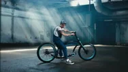 4K Cinemagraph - Caucasian Male In Denim Overalls Sits On A Custom Made Bicycle Stock Footage