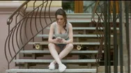 4K Cinemagraph - Girl With Longboard Listening To Music On The Phone Stock Footage