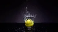 4K Cinemagraph Of Lemon Falling Into Glass Of Water Stock Footage