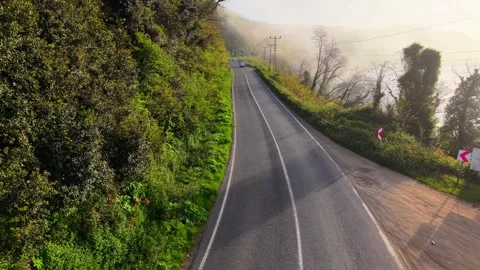 4K Cinematic Drone Flying Backward Above a Foggy Coastal Road Stock-Footage 339265880