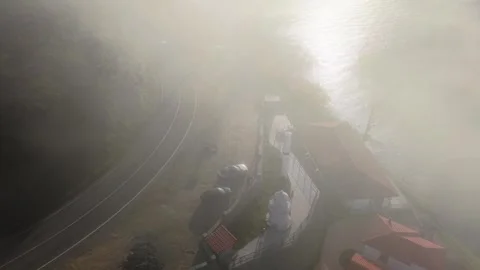 4K Cinematic Drone Flying Through Fog Toward a Coastal Road Stock Footage 339270261