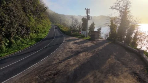 4K Cinematic Drone Pullback Above Foggy Road with Cars and Motorcycles at Sunset Stock-Footage 339271097