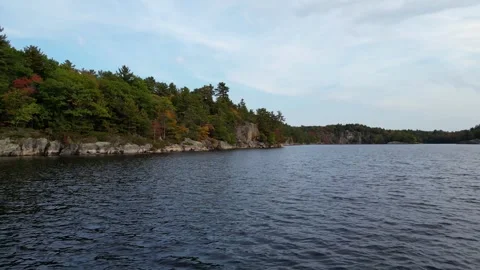 4K Cinematic Flight Over The Clear Water Past The Rocky Shores Of The Lake Stock Footage 256942729