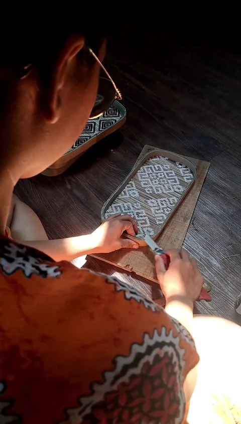 4K Cinematic Over-the-Shoulder View: Artisan Woman Making Handicraft in Dramatic Stock Footage 338270491