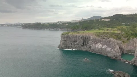 4K Clockwise Drone Shot of a Hill West to Ohoedolgase (외돌개), Jeju Island Stock Footage 143863775