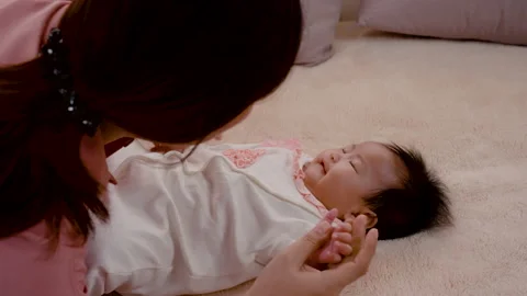 4K, Close Up A 3-month-old newborn girl is laying in bed for joy and her moth Stock Footage 203894348