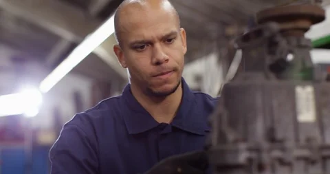 4K Close up of attractive mixed race mechanic working in garage workshop Video stock 103063433