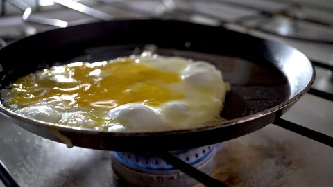 4k. Close-up of breaking and dropping one egg in a frying pan for breakfast. Stock Footage 100970325