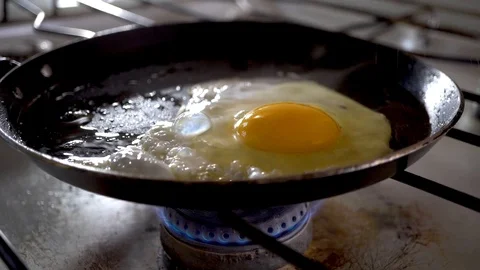  4k. Close-up of breaking and dropping one egg in a frying pan for breakfast. Stock Footage 100971884