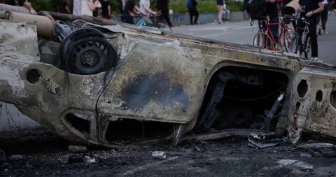 4K CLOSE UP OF BURNT UP CAR THAT HAS BEEN FLIPPED OVER Stock Footage 131460477