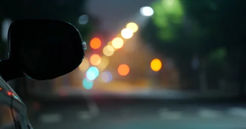 4K CLOSE UP CAR REAR VIEW MIRROR RACK FOCUS TO CITY STREET AT NIGHT Stock Footage 131124723