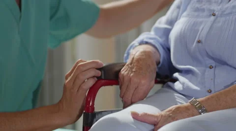 4K Close up caring nurse holding hand of elderly female patient in a wheelchair Stock Footage
