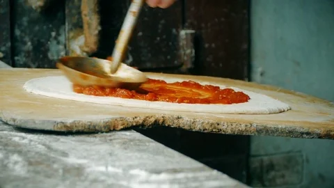 4K, Close-up of a chef spreading tomato sauce on pizza dough Stock Footage 78019998
