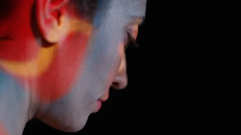 4K Close up colorful patterns of light projected onto face of attractive model Stock Footage 66588033