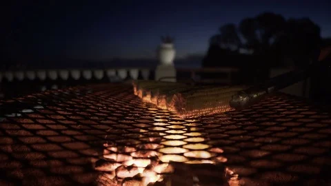 4K Close up corn cobs cooking on barbecue grill at beach hotel at night Stock Footage