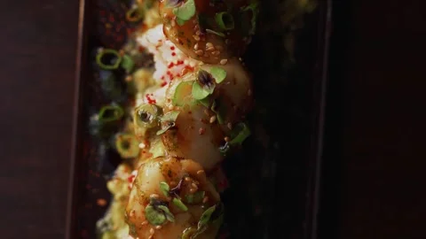 4K close up creative scallop sushi roll sliding on table - cinematic video Stock Footage 315123116