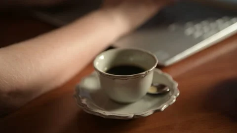 4k close up of cup of coffee and female hands typing a text on a laptop. Stock Footage 161064236
