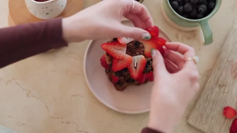 4K Close-up Cutting Strawberry to Garnish Muffin or Cake with Blue Video stock 330480648