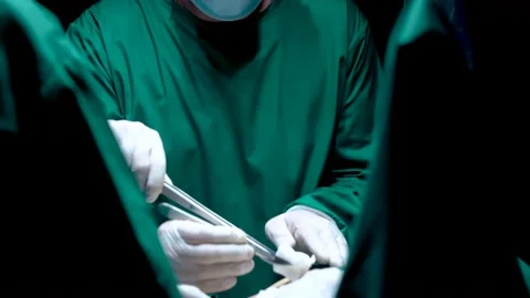 4K, Close-up, doctor's face, and doctor's assistant's hand soaking up blood Stock Footage 232323716