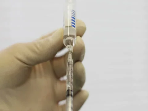 4K Close up of doctor's hands in gloves filling syringe with injection liquid. Stock Footage 73396313