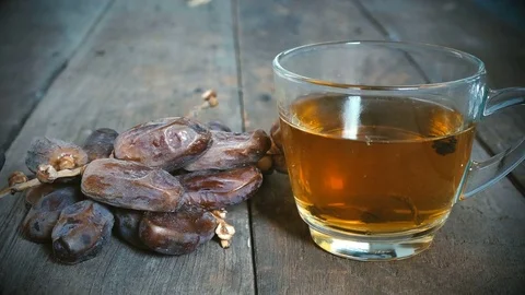 4K, close up dolly, palm dates fruit with cup of tea on old wood table Stock Footage 78047212