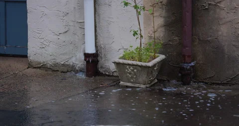 4K CLOSE UP OF DRAIN PIPES OVERFLOWING WITH WATER IN THE RAIN Stock Footage 131127231
