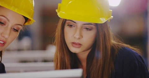 4K Close up on faces of two beautiful female engineers checking factory machine Stock Footage 102024793