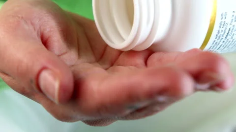 4k close-up footage two transparent tablets fall out of the jar into the hand Stock Footage 240604597