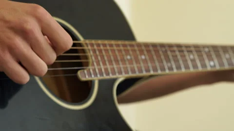 4K close up of Guitar strings on black guitar being played by caucasian fingers Stock Footage 62341915