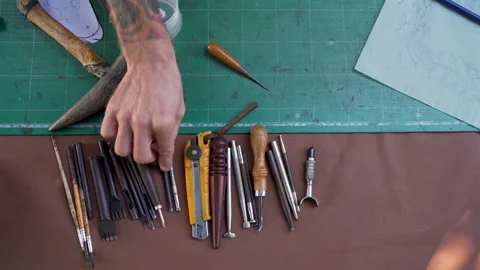 4K, close-up hand being picked up selection handcrafted leathercraft tools .. Video stock 234070108
