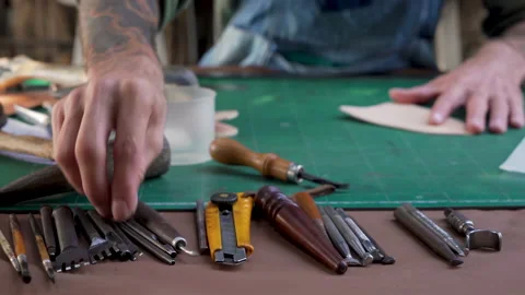 4K, Close-up hand being picked up selection handcrafted leathercraft tools .. Video stock 238438682
