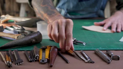 4K, Close-up hand being picked up selection handcrafted leathercraft tools .. Video stock 238754648