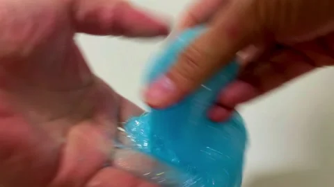 4K close-up of a hand manipulating blue glittery slime Stock Footage 288688485