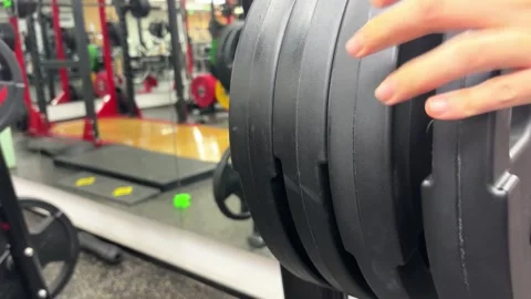 4K Close Up of Hand Placing Heavy Weight Plate on Gym Peg Stock Footage 329336516