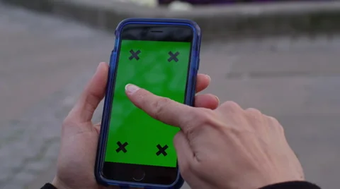 4K Close up of hand using a smartphone with green screen display outdoors Stock Footage 57291588