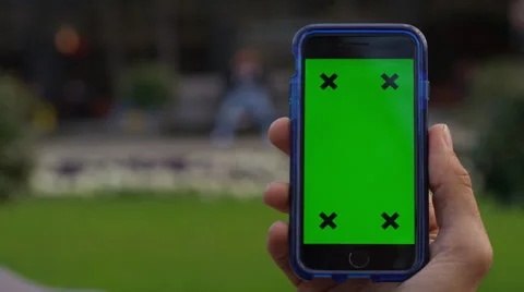 4K Close up of hand using a smartphone with green screen display outdoors Stock Footage 57293700