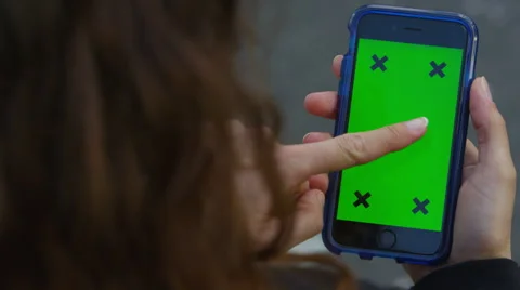 4K Close up of hand using a smartphone with green screen display outdoors Stock Footage 57296802