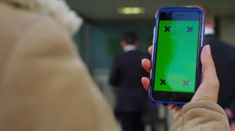 4K Close up of hand using a smartphone with green screen display outdoors Stock Footage 57300501