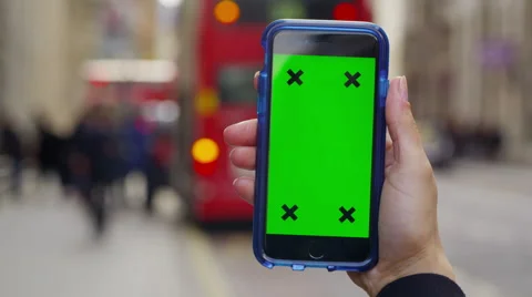 4K Close up of hand using a smartphone with green screen display outdoors Stock Footage 57302758