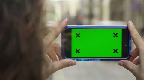 4K Close up of hand using a smartphone with green screen display outdoors Stock Footage 57303136