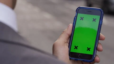 4K Close up of hand using a smartphone with green screen display outdoors Stock Footage 57303427