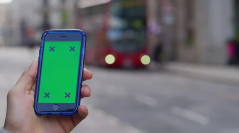 4K Close up of hand using a smartphone with green screen display outdoors Stock Footage 57303878