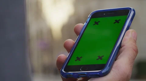 4K Close up of hand using a smartphone with green screen display outdoors Stock Footage 57304878