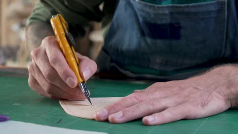 4K, Close-up handcrafted leather worker sits farts cowhide with cutter acco.. Stock Footage 234070002