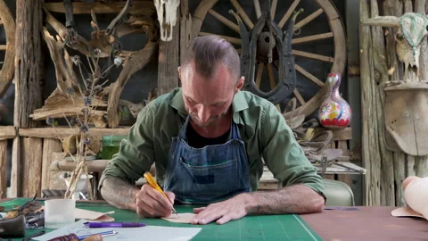 4K, Close-up handcrafted leather worker sits farts cowhide with cutter Stock Footage 238438681